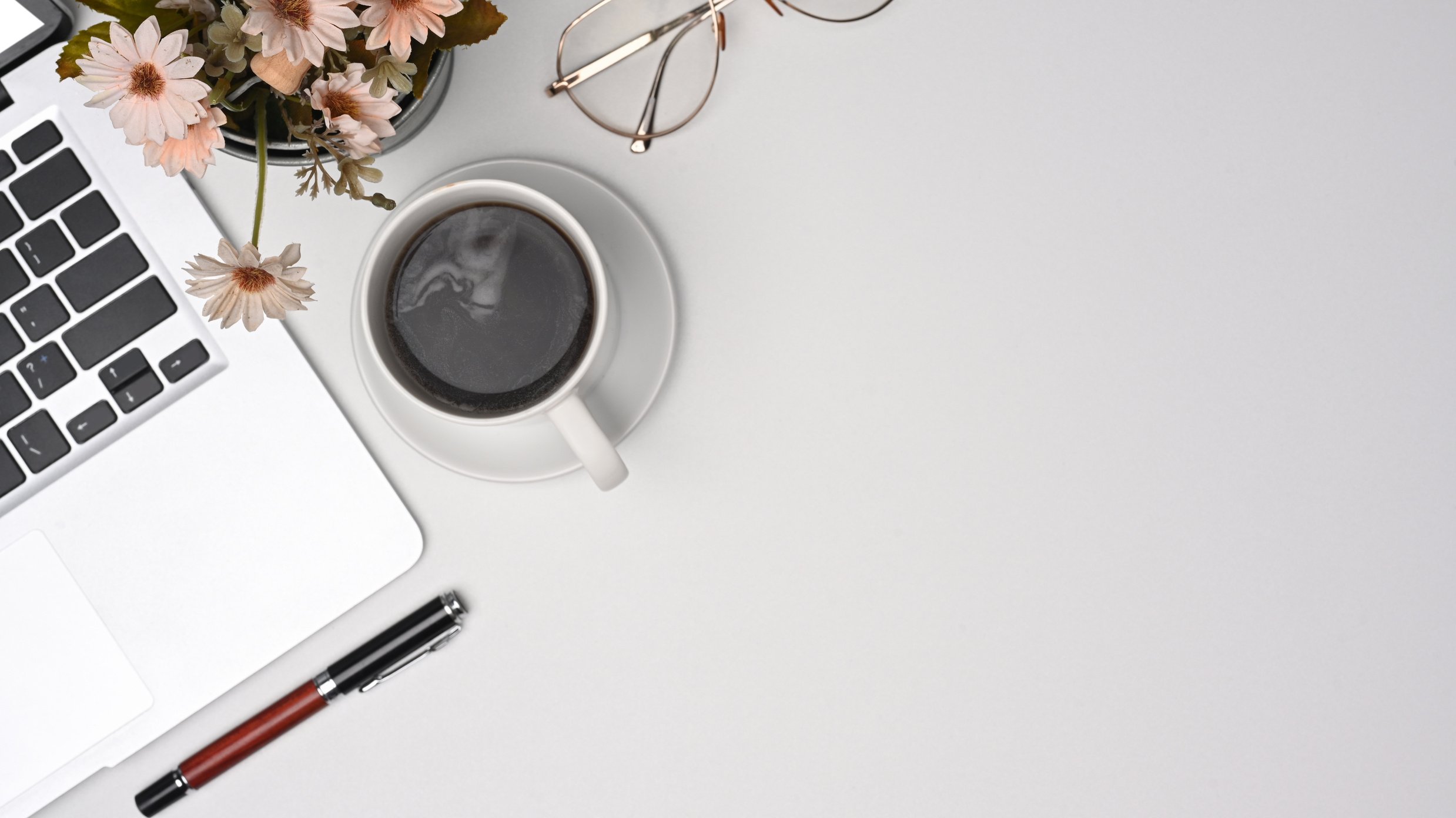 Simple Workspace with Laptop Computer, Coffee Cup and Glasses.